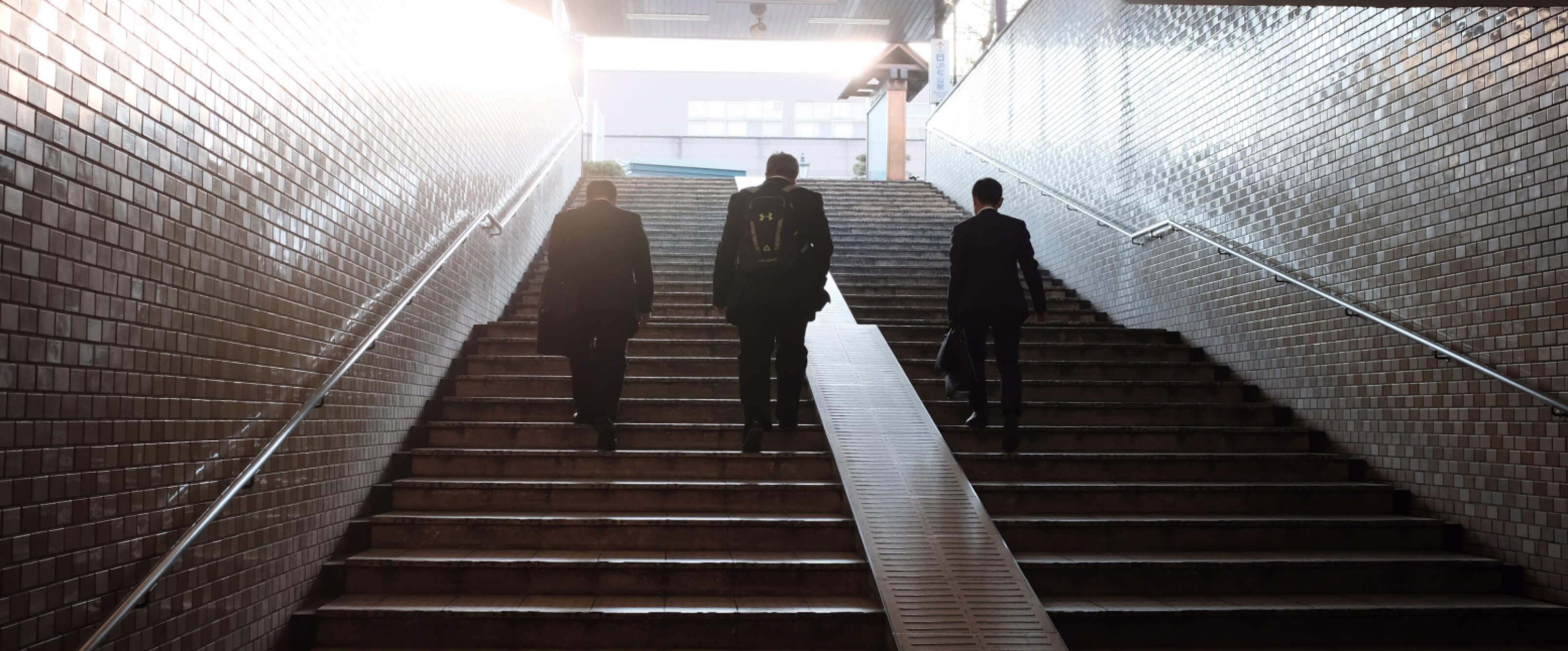 Three Men Walking Up Stairs